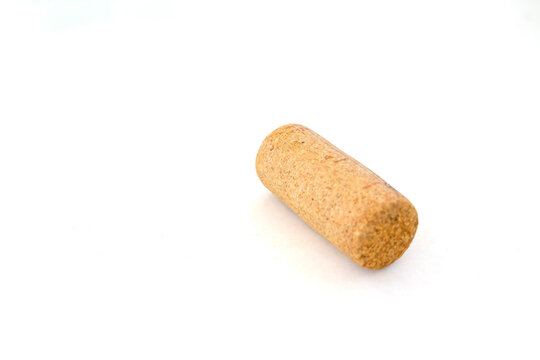 ingle wooden wine cork lying on a white background with copy space