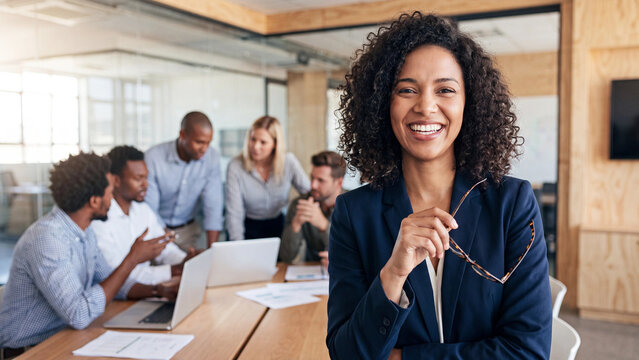 Confident businesswoman smiling in a modern office while colleagues collaborate behind her for corporate leadership and teamwork marketing