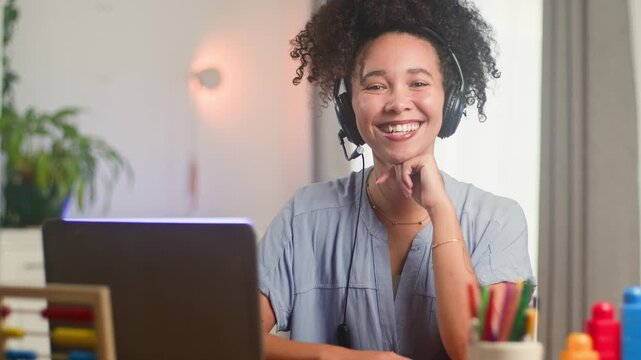 Smiling Black Woman, An Online Teacher With Natural Hair, Engages in Remote Education with a Headset and Laptop