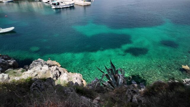 Luka Rovenska harbor on Losinj Island. Croatia. Showing a charming waterfront village with multi-colored houses. Boats. And crystal-clear turquoise water under blue sky of Losinj Island in Croatia