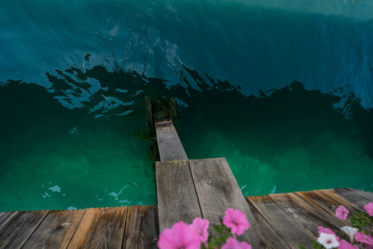 Turquoise water reuss river lake wooden dock pier balcony flowers lucerne switzerland outdoor view summer daylight concept
