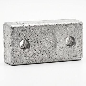 Macro of a raw zinc sacrificial anode block with matte porous texture for boat hull protection, isolated.