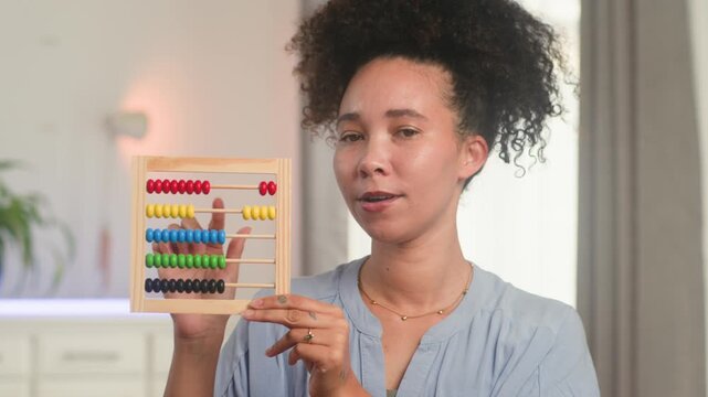 Smiling Black Woman Teacher Demonstrates Math with an Abacus for Online Remote Learning