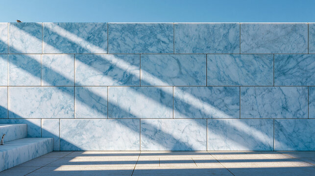 Blue marble wall with geometric pattern and bright sunlight casting sharp shadows on floor.