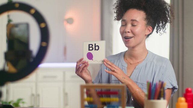 Smiling Black Woman Online Teacher Teaches English Alphabet Remotely to Primary School Students