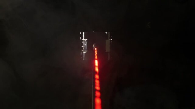 A SciFi laser gun through smoke on black background