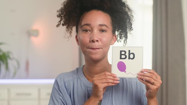 Smiling Black Woman Online Teacher Teaches English Alphabet Remotely Using Flashcards