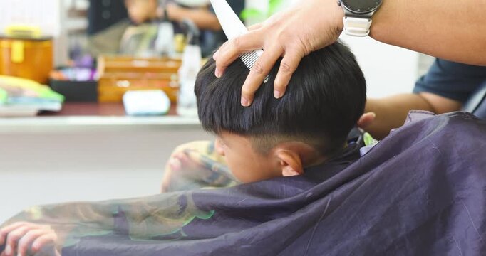 Little school asian boy enjoy hair cut barber shop service fashion concept