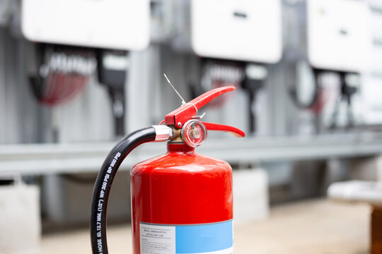 Red fire extinguisher installed on the solar cell fire extinguishing system control cabinet.