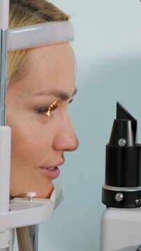 Young female patient undergoing a professional eye examination in a modern ophthalmology clinic, with a specialist using advanced diagnostic equipment to check her vision and health