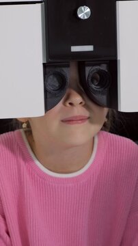 Young girl patient having her eyesight checked by a professional ophthalmologist using a modern phoropter machine in a hospital, a medical diagnostic procedure for her vision