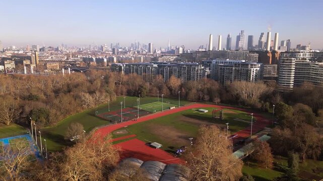 Aerial panoramic view of an athletics track and London skyline at sunrise 