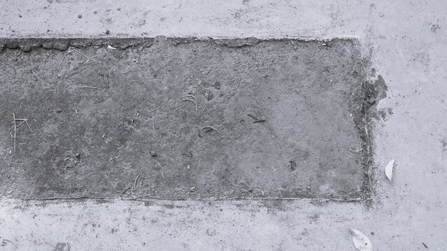Monochrome concrete patch texture with rough cement surface, aged construction details and subtle dirt. Black and white industrial background.