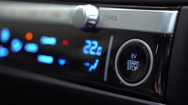 Finger Pressing EV Start Stop Engine Button Turning On Electric Vehicle Dashboard