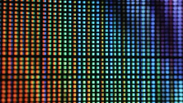 Abstract macro shot of a television screen with a grid of colorful pixels changing pattern