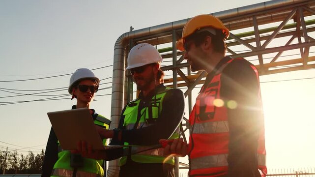 Team technicians consulted prepared blueprints field inspection automotive parts manufacturing plant industrial estate inspection supporting structures pipes process mains factory's rstructure.