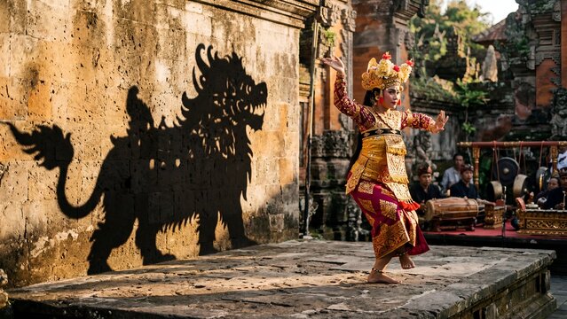 Balinese dancer performing traditional ritual with dramatic shadow on temple wall