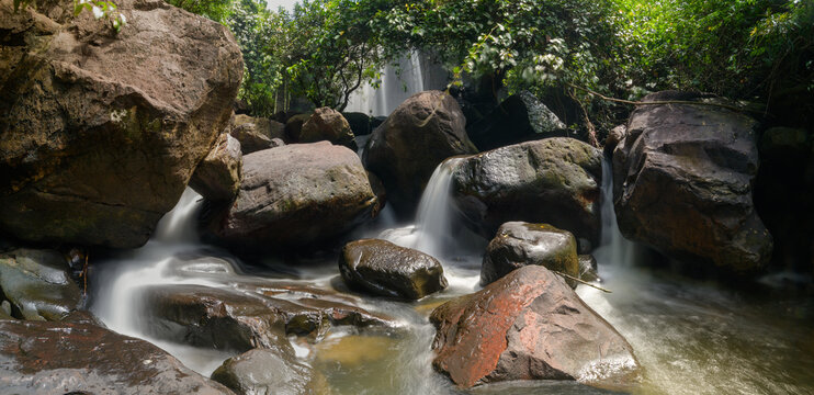 Tranquil Forest Stream with Flowing Water and Large Boulders