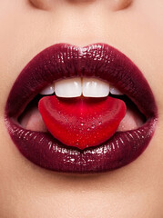 Fototapeta premium Glossy berry lips holding a red rose petal, representing passionate New Year romance and luxury holiday beauty campaigns.