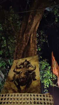 Poster of Lord Shiva Riding Nandi Placed Against a Large Tree