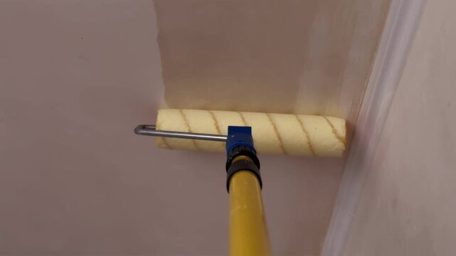Priming high apartment ceiling with roller on telescopic extension pole