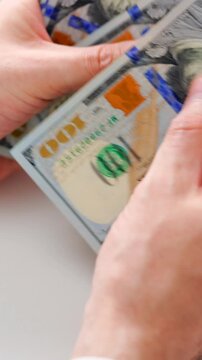 Male hands counting US Dollar bills, close-up