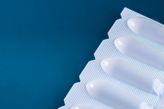 White Suppositories in Blister Pack on Blue Background, Medical Medication Packaging and Healthcare Concept