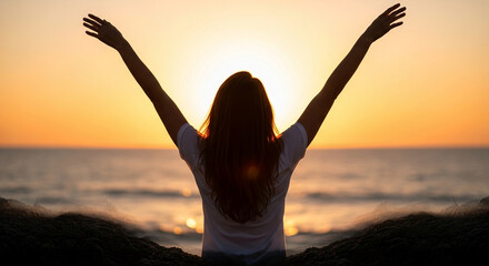 Fototapeta premium Silhouette of person with arms raised against a golden sunset over the ocean, symbolizing freedom, joy, and hope.