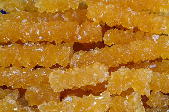 Golden Novvot sugar rock or nabat, navat, Persian or Uzbek sugar. Type of rock candy. Traditional Central Asian crystallized sugar. Prepared from sugar syrup and grape juice. Sweet background