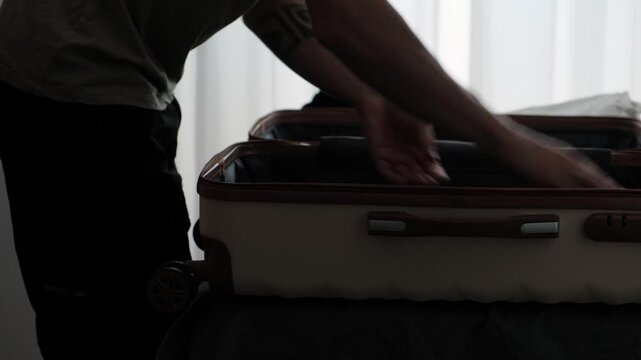 Constant relocation and temporary living. Close up of packing personal belongings into suitcase before another move, authentic lifestyle routine