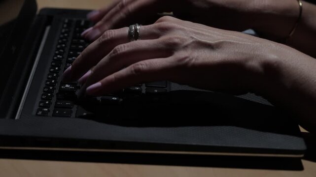 Close-up view of female hands typing on a laptop keyboard in a modern business office, illustrating professional work, technology, productivity, and digital communication