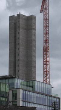Tall skyscraper building under construction crane next to concrete interior elevator shell