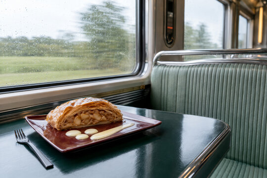 Disfrutar de un strudel de manzana en un tren mientras se viaja por el campo