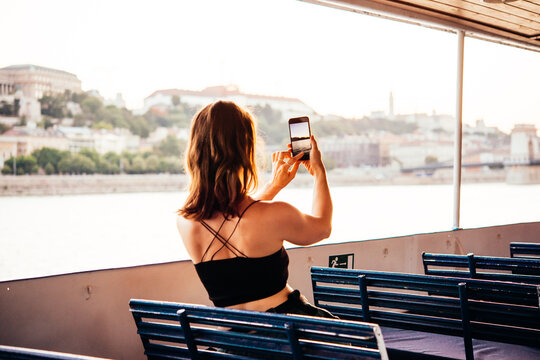 A person takes a mobile photo of a landscape while travelling.
