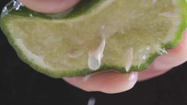 Close-Up Squeezing Kaffir Lime with Dripping Juice