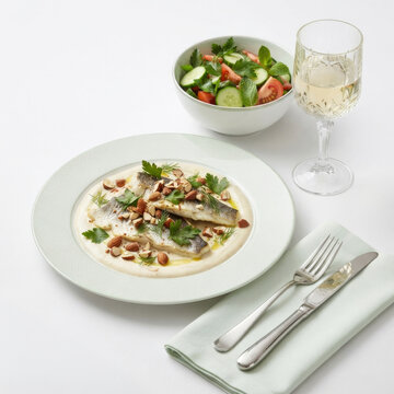 Roasted sea bass with creamy sesame sauce, crunchy nuts, fresh salad, and white wine