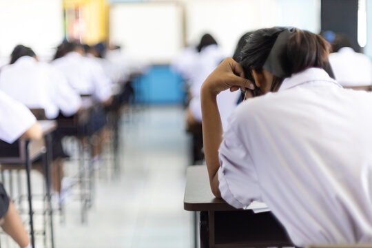 Back View of High School Students Concentrating on Difficult Exam in Classroom