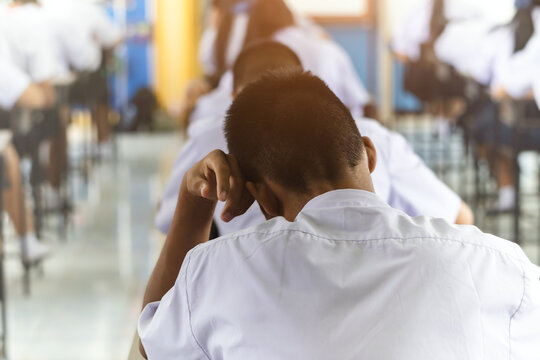 Back View of High School Students Concentrating on Difficult Exam in Classroom