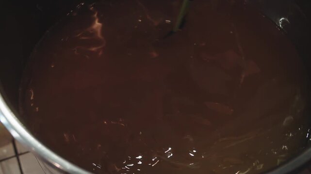 Process of homemade soap. Stir liquid in large saucepan. Rotation of viscous liquid in container. Close up view