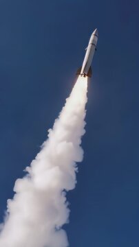 Rocket ascending through blue sky with thick smoke trail. Low angle tracking shot of spacecraft launch.