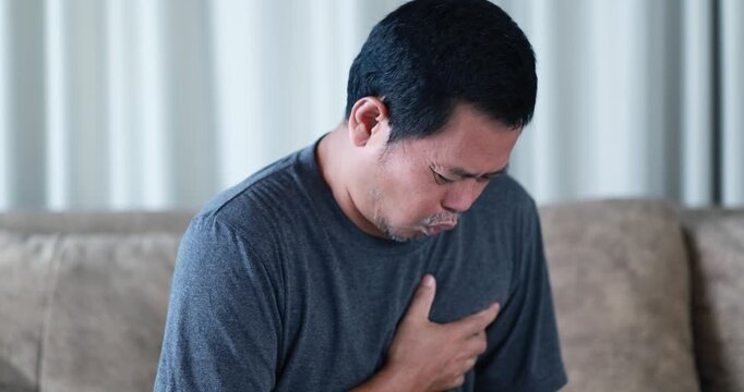 Adult man clutching his chest in severe pain, heart attack, chest pain, medical emergency, cardiovascular disease, healthcare, emergency treatment, and health risk