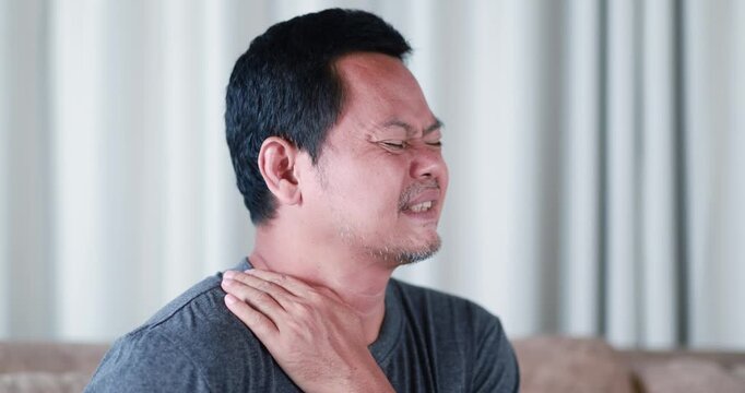 Adult man massaging his neck to relieve neck and shoulder pain, shoulder and upper back pain, muscle stiffness, office syndrome, fatigue, poor posture, self massage, pain relief, healthcare concept