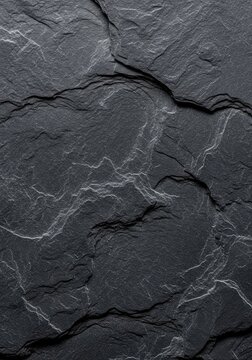 A high-resolution texture of dark charcoal grey slate stone showing natural cracks and rough grain for industrial or minimalist background, design, tile, natural