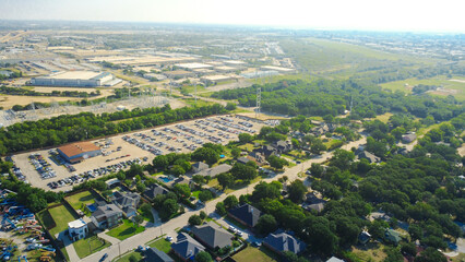 Fototapeta premium Quiet neighborhood streets wind through mature tree clusters situated north of S. Irving Heights Drive holding lots. Single family homes integrate with industrial boundary fences in Irving, TX