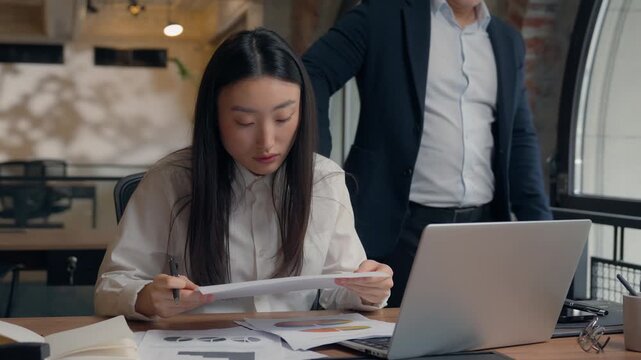 Asian woman intern arguing business man about papers laptop data two Korean colleagues conflict paperwork incorrect computer stats in office teamwork trouble businesswoman Chinese Japanese businessman