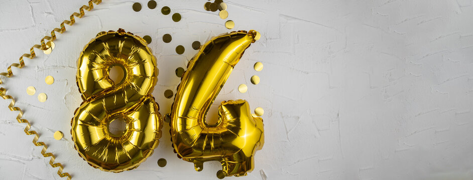 Yellow Gold foil balloon number eighty-four on white background. Birthday card with lettering 84. Anniversary concept. For anniversary, birthday, wedding event, new year celebration. Banner