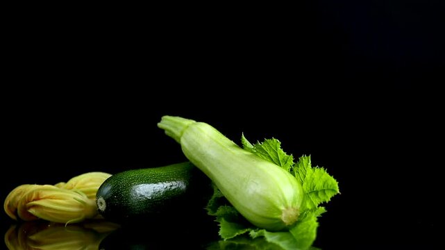 squash vegetable with vibrant blossom on dark reflective background