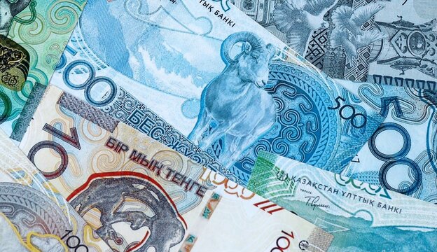 Kazakhstani tenge money bills in pile on table. Kazakhstan KZT currency cash close up