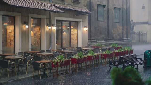 Rainy day outside a cozy cafe with empty tables and warm lights