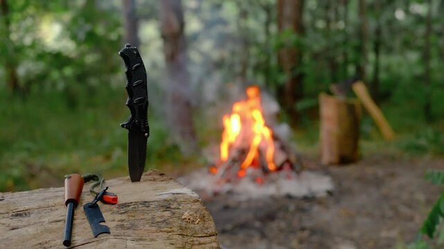 Cinematic B-Roll of Survival Knife and Firestarter in Wood Log with Campfire in Background, Crackling Sound, Outdoor Bushcraft Camping, Wilderness Gear Video Footage.